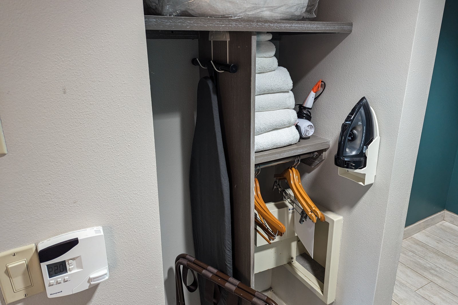 hotel closet area with iron, safe and extra towels