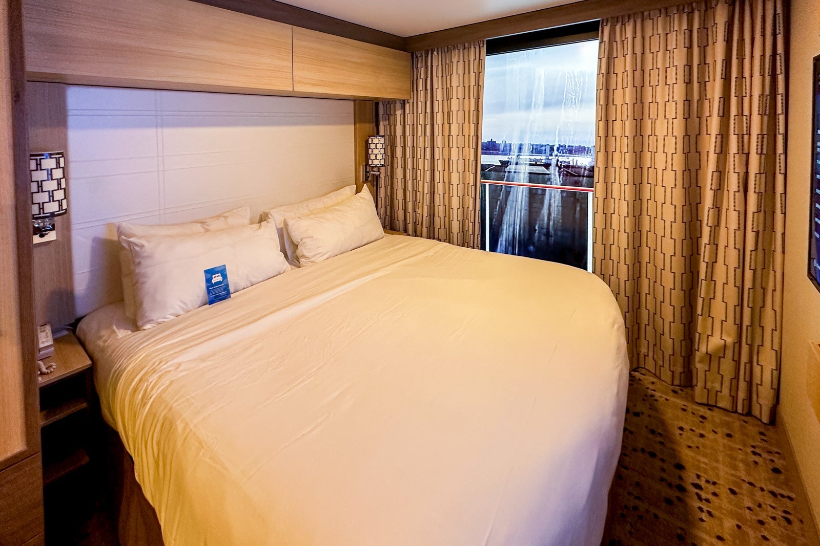 A cruise balcony cabin with a king bed and a virtual balcony screen