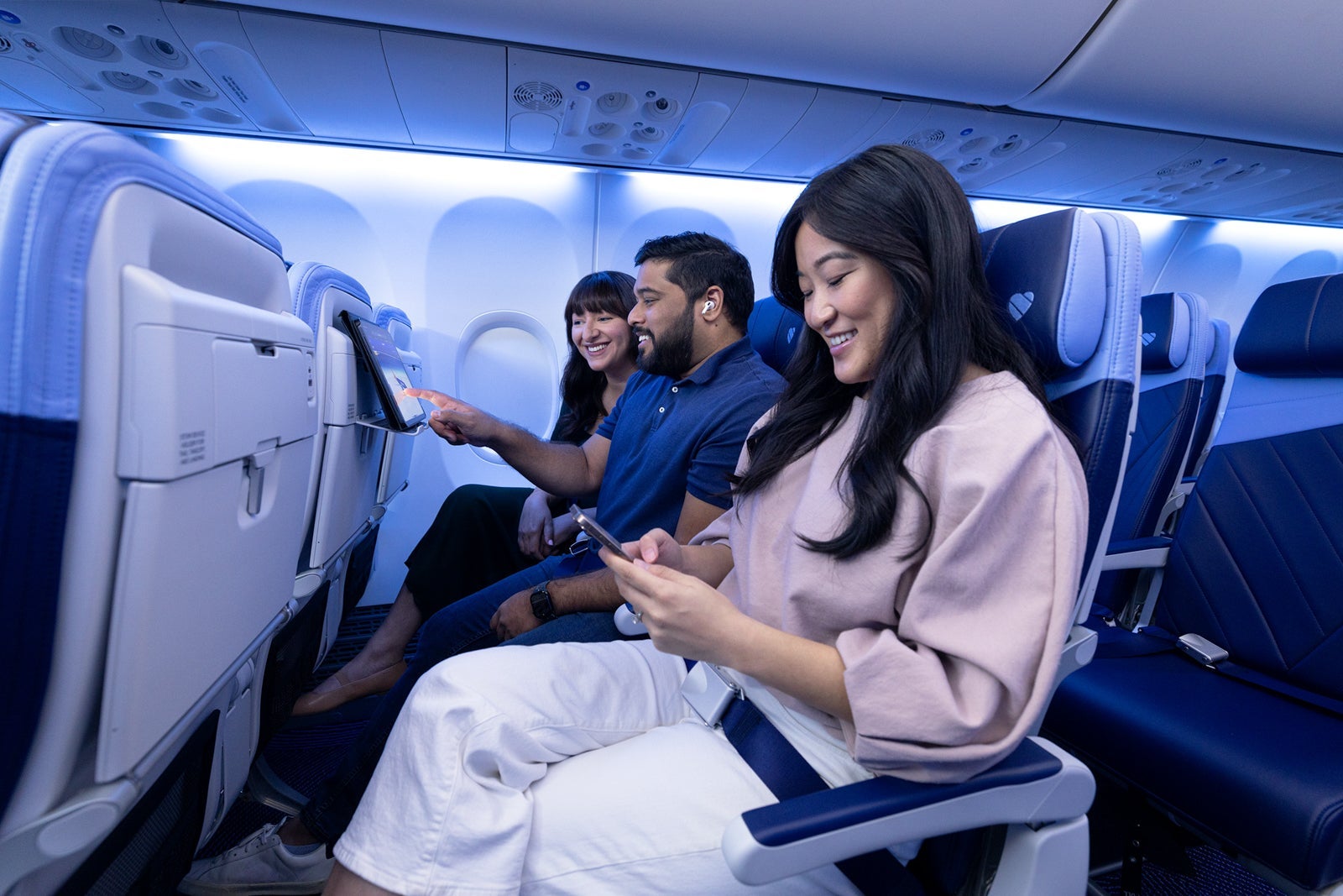Three people sitting on a plane