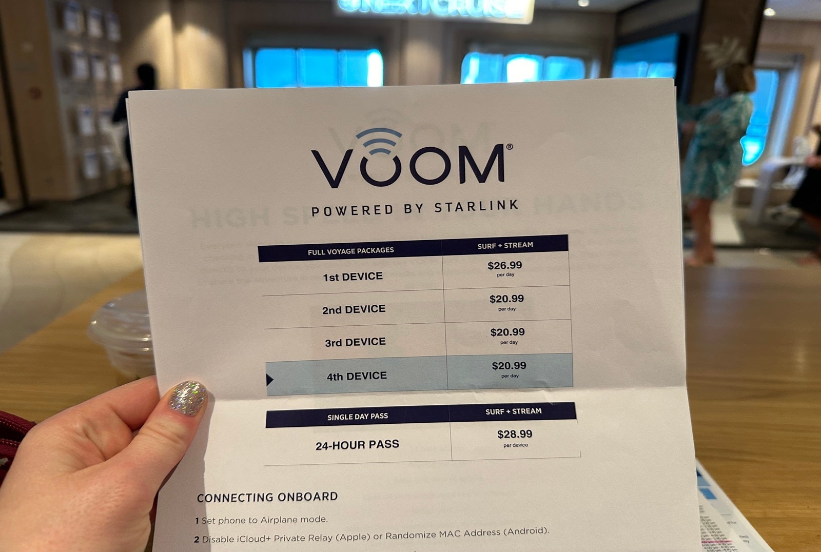 A disembodied hand holding a Voom internet price list
