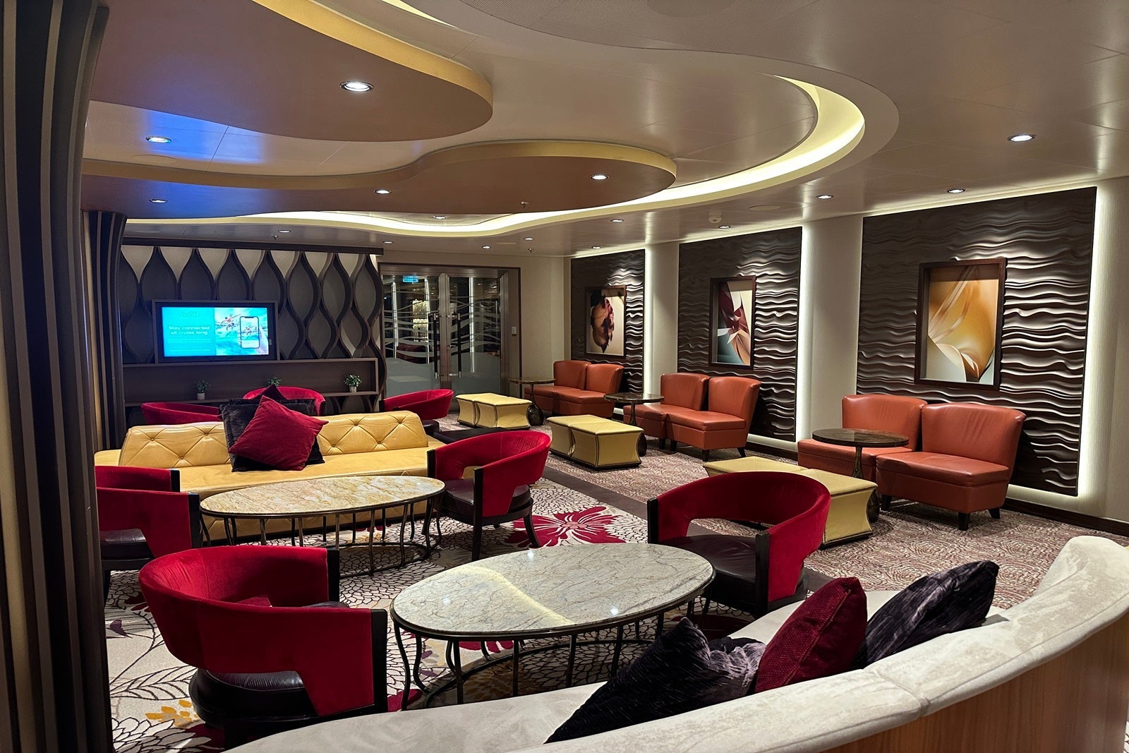 A neutral-colored lounge with red chairs.