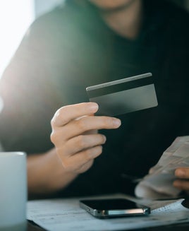 Cropped shot of young Asian woman holding credit card and expense receipts, handing personal banking and finance at home. Planning budget, calculating expenses and managing financial bills. Home budgeting. Home finances. Digital banking habits