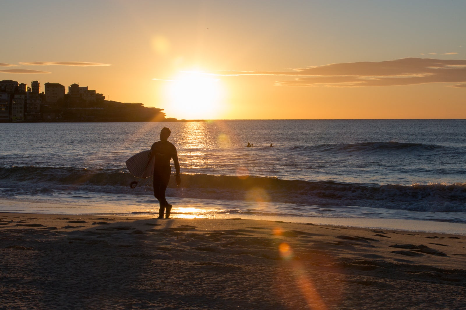 A male emerges from the surf at sunrise on Bondi Beach