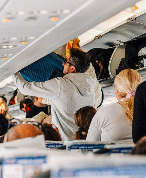 Putting bags in overhead bin on plane