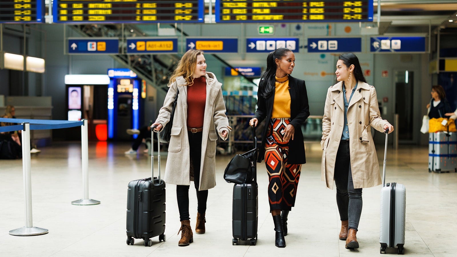 Three Businesswomen Walking Together To Catch A Flight