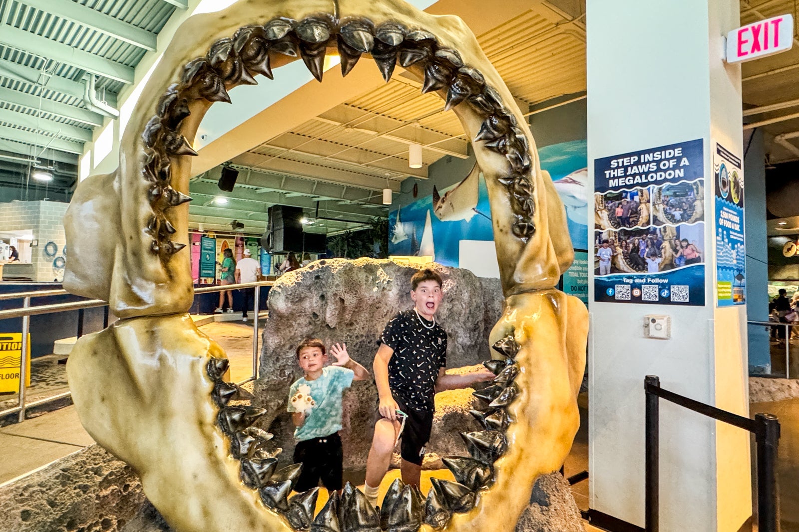 Boys posing in giant megalodon jaw