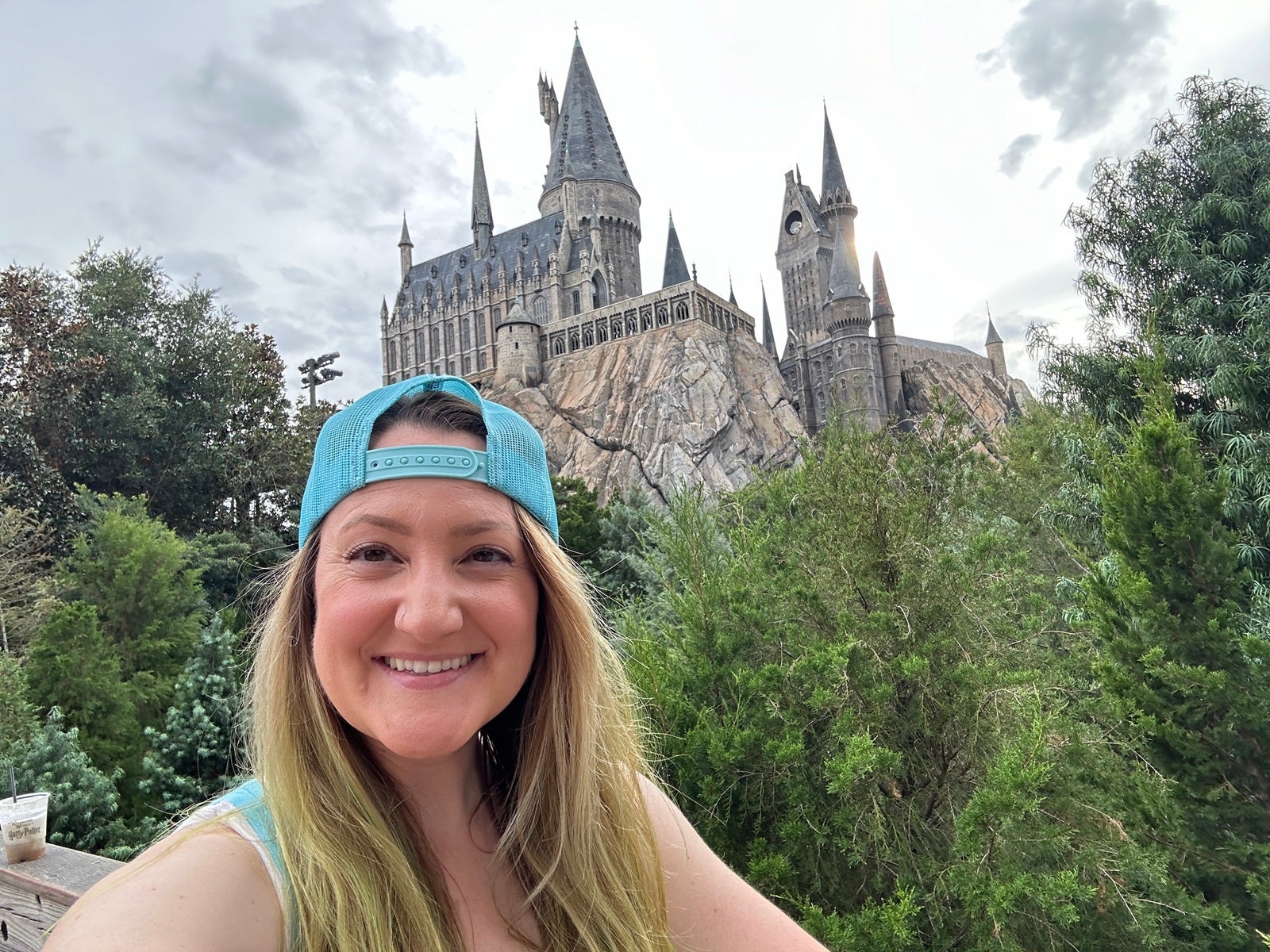 A woman taking a selfie in front of a Hogwarts Castle