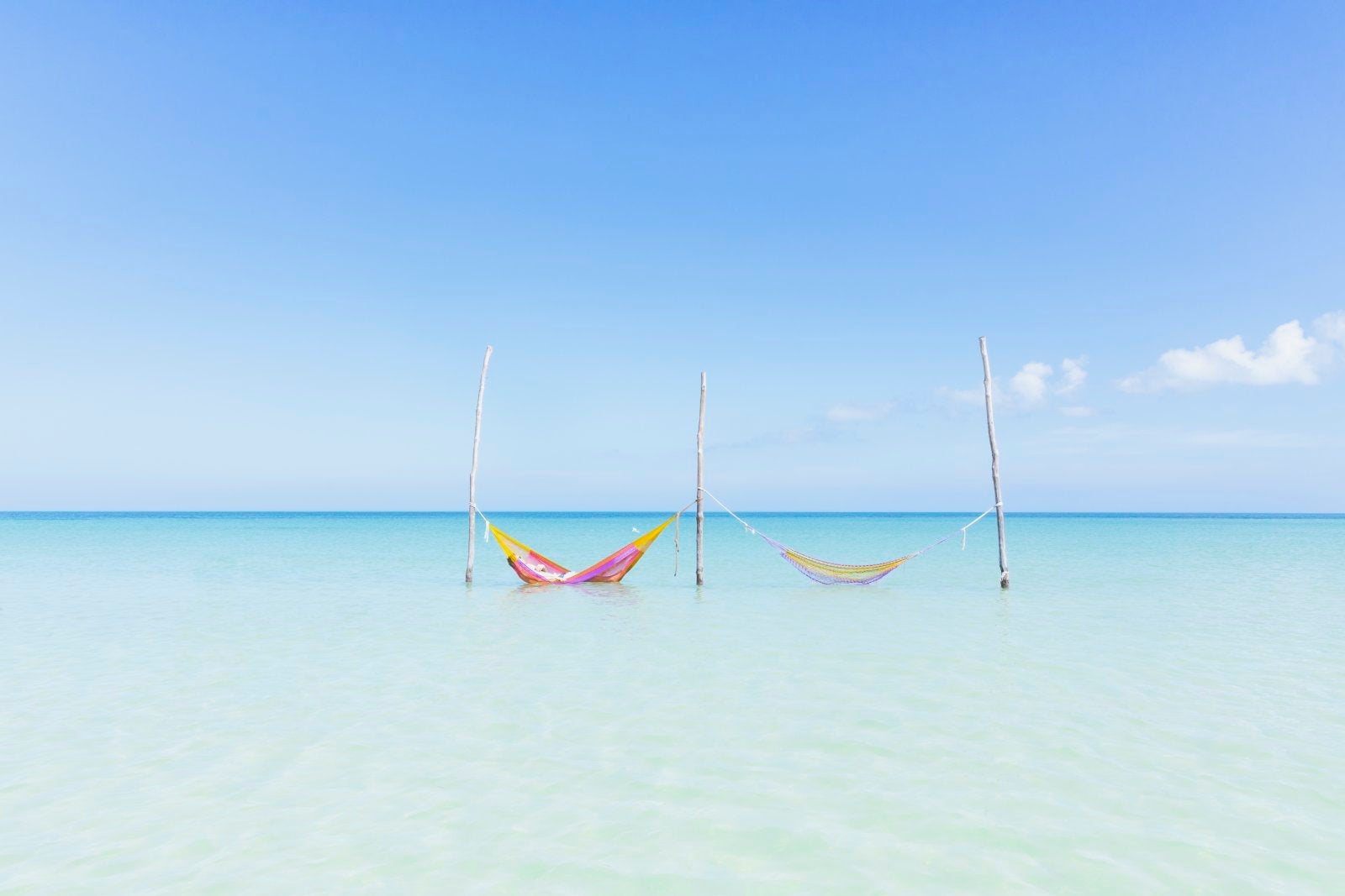 Two hammocks in the crystal clear turqoise water at a beach on the Island of Holbox, Mexico
