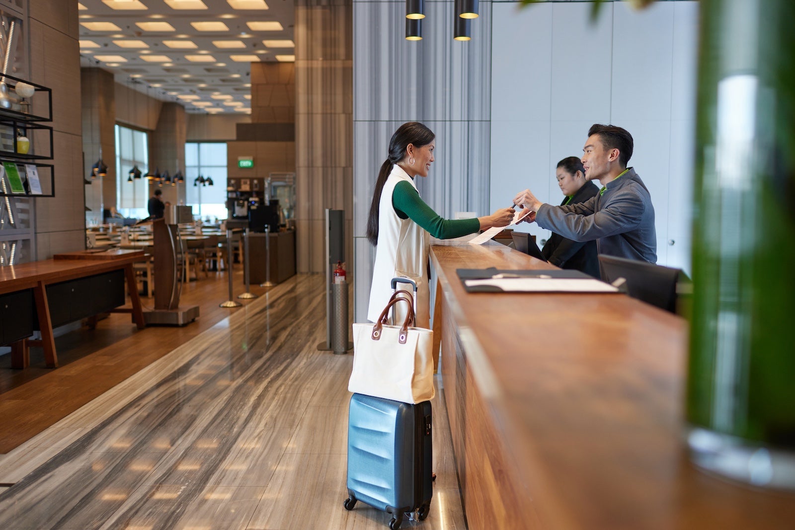 Business travel - A beautiful asian female professional on business trip checking into the hotel