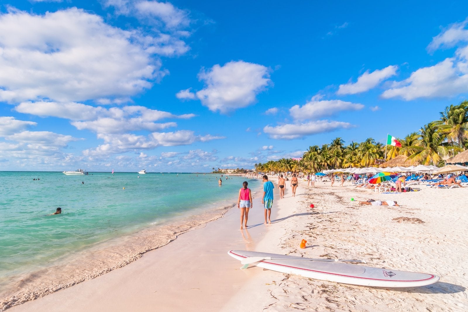 Isla Mujeres, Mexico - April 21, 2014: tourists enjoy tropical sea on famous Playa del Norte beach in Isla Mujeres, Mexico. The island is located 8 miles northeast of Cancún in the Caribbean Sea.