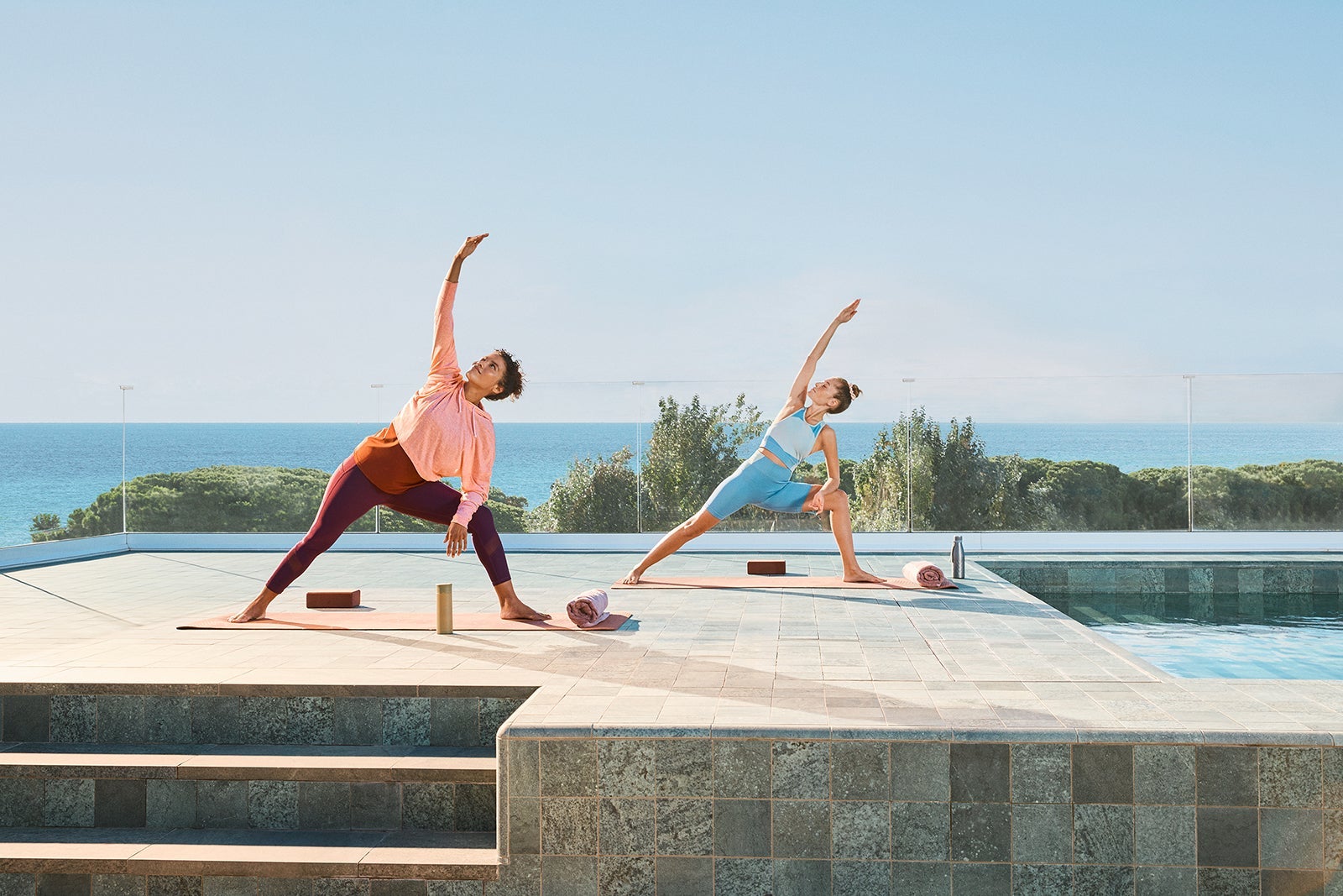 People doing yoga on pool deck