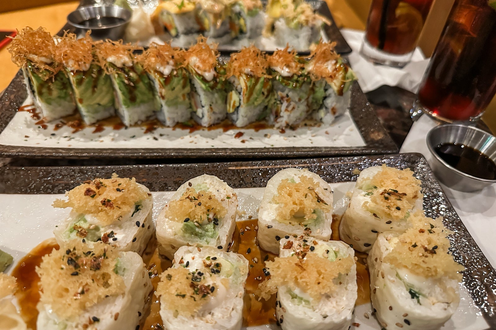 Several sushi rolls on long, rectangular plates