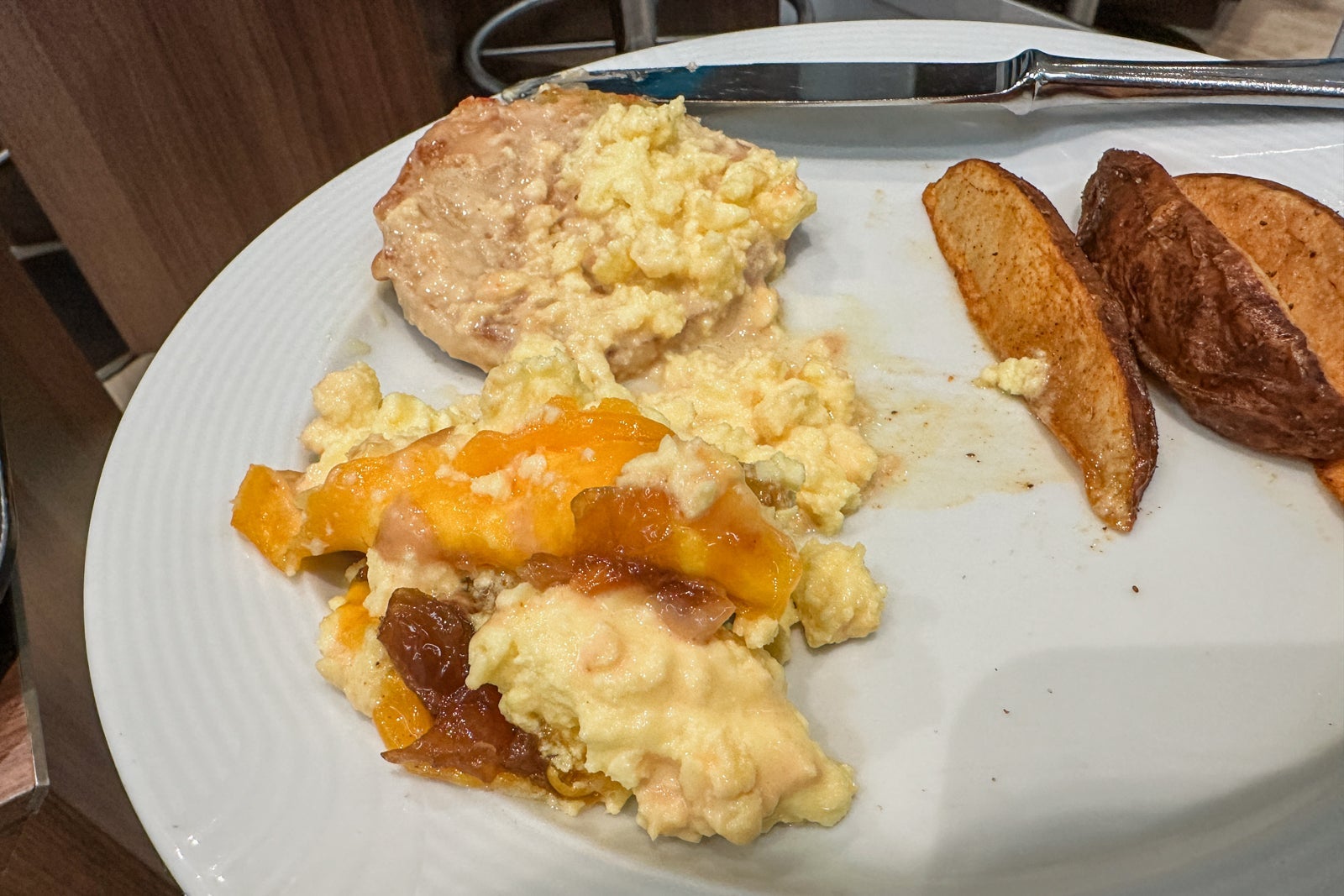 A pile of eggs and cheese on an open-face English muffin