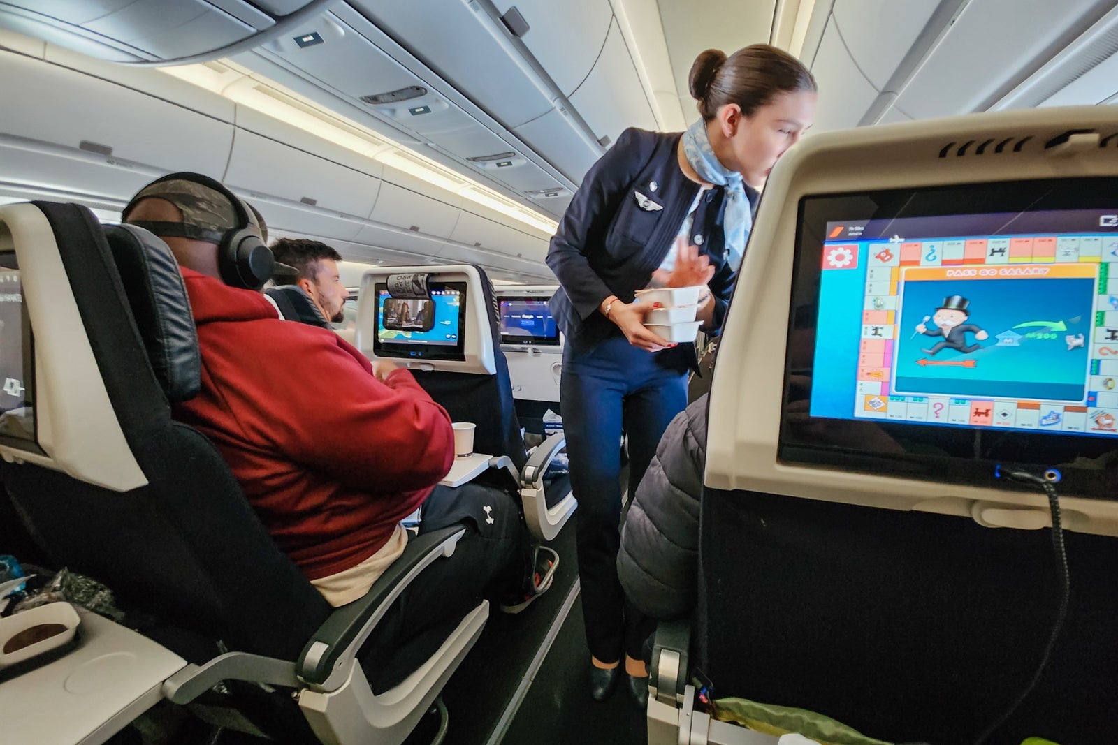 flight attendant in aisle offering leftover meals