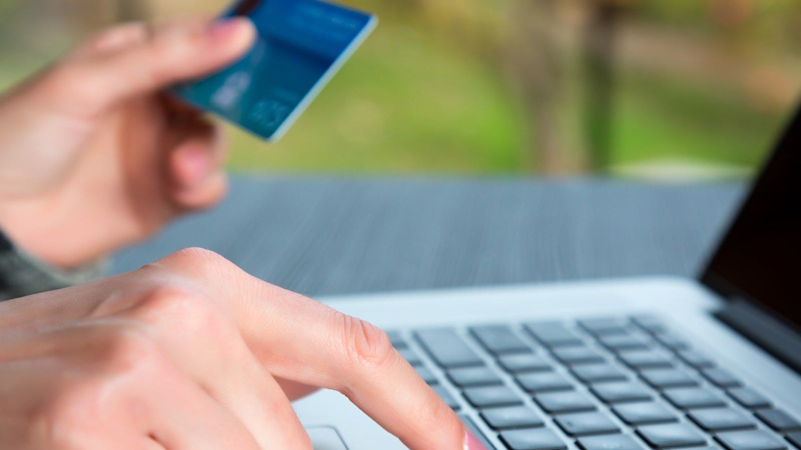 Hands of person entering credit Card Data on Laptop