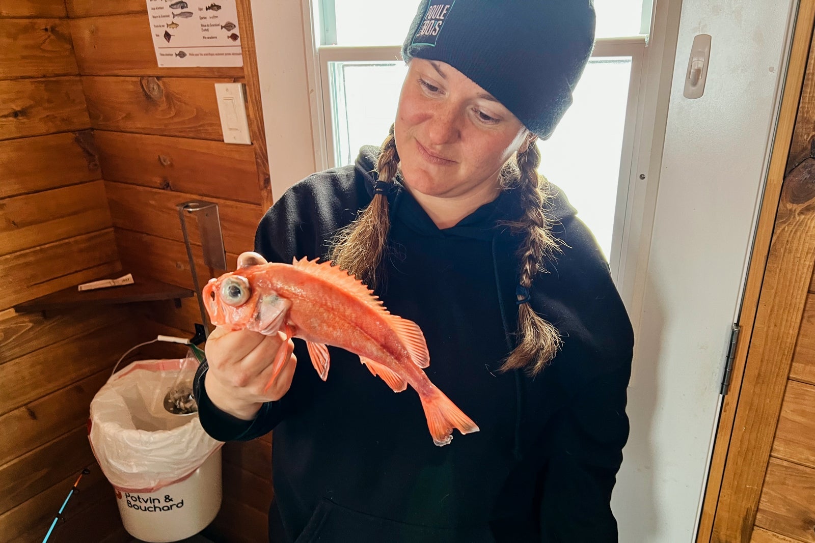 A guide shows off a fish caught during an ice fishing excursion on Saguenay Fjord