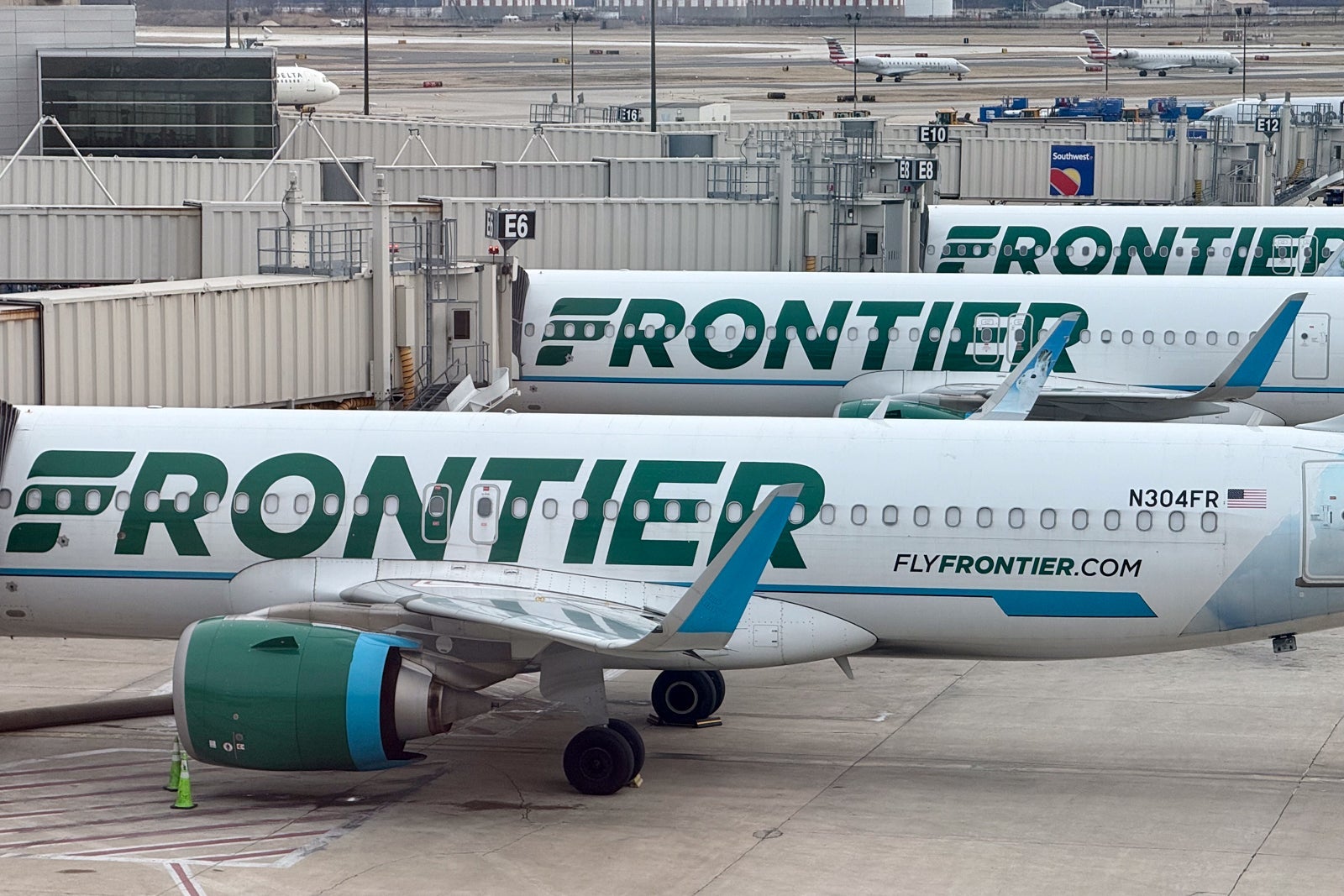 Frontier Airlines planes parked at airport gates