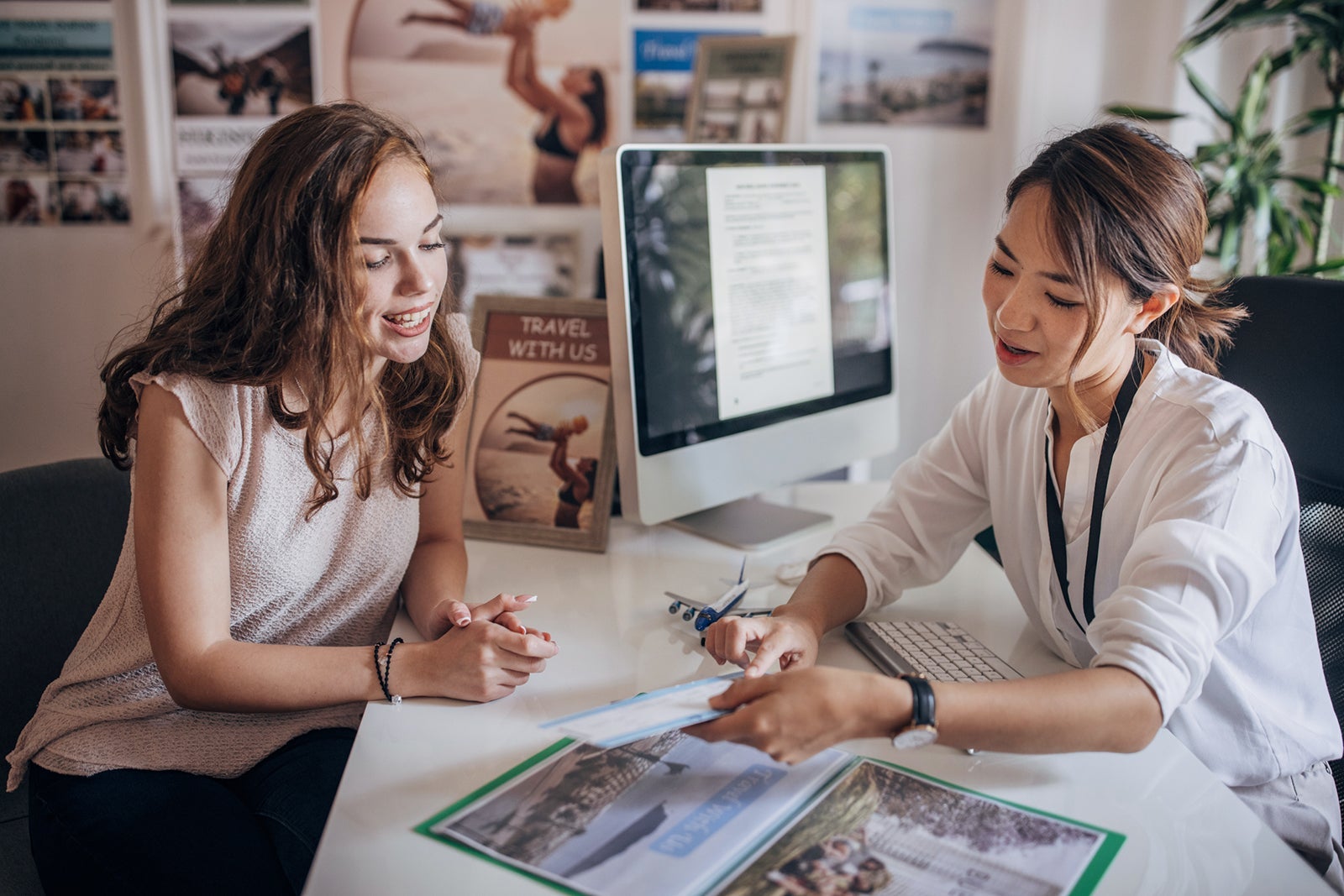 Woman booking travel with an agent at her desk
