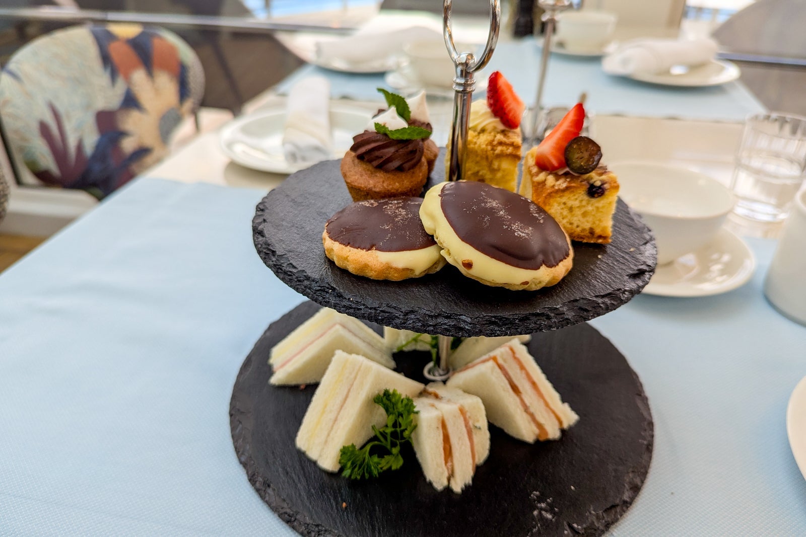 Two-tiered tray of finger sandwiches and small pastries