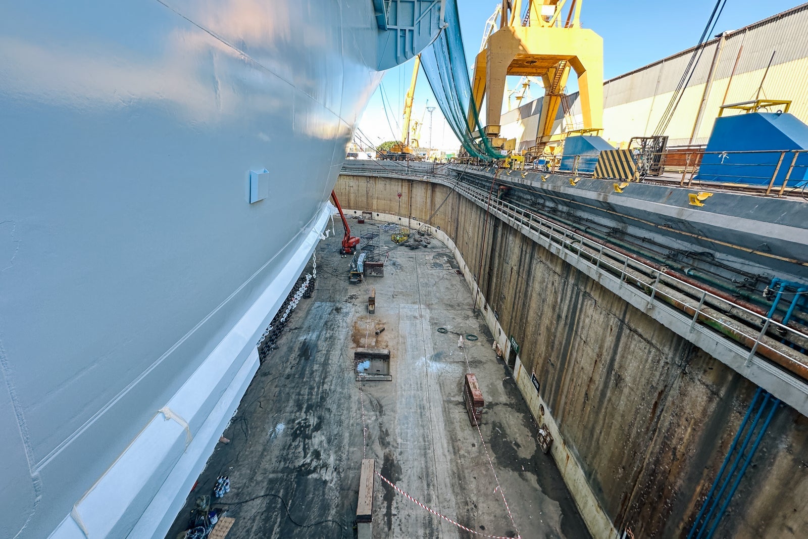 A view of part of a ship's hull while it's in dry dock at a shipyard