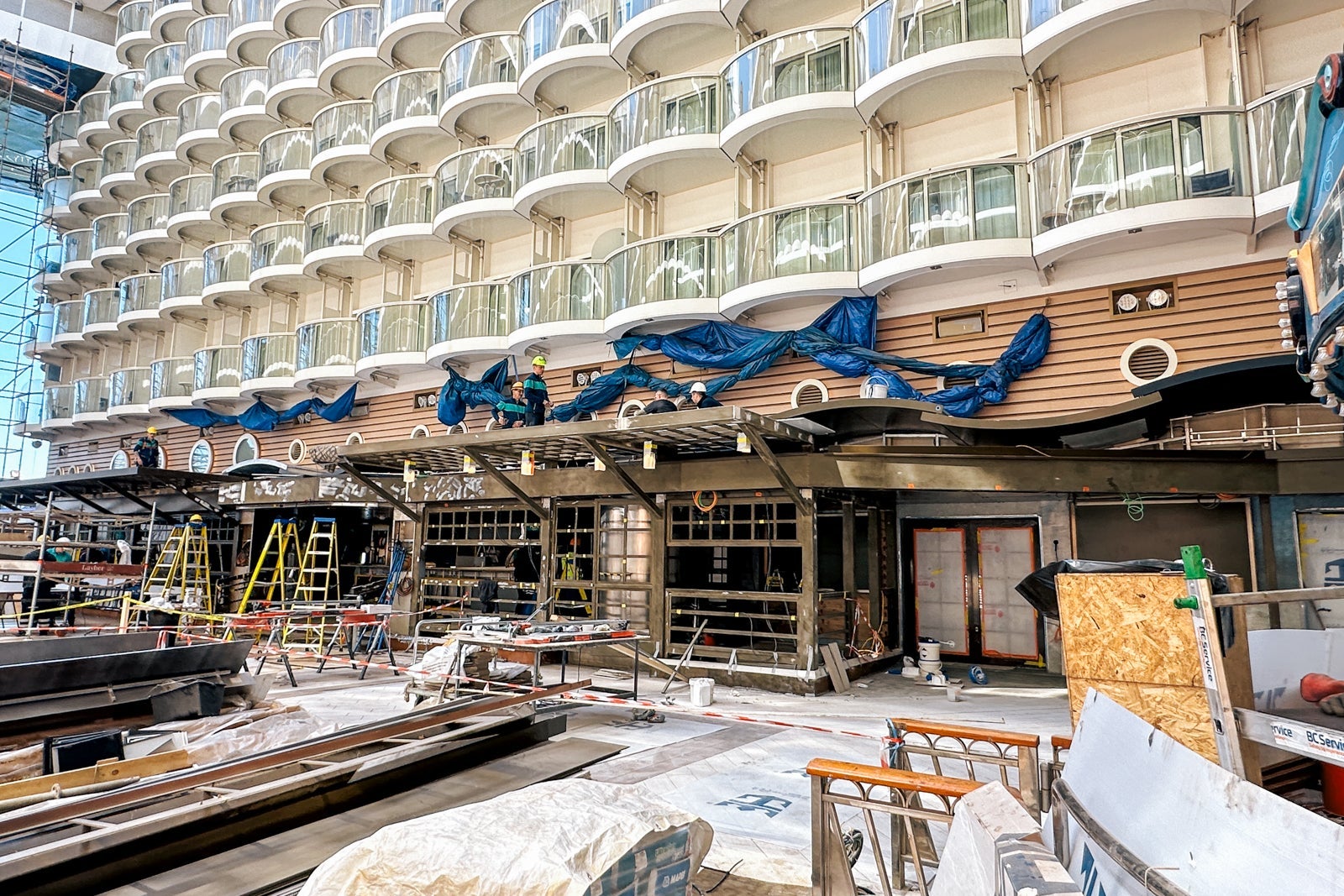 An unfinished cruise ship restaurant under construction with several inward-facing balcony cabins above it