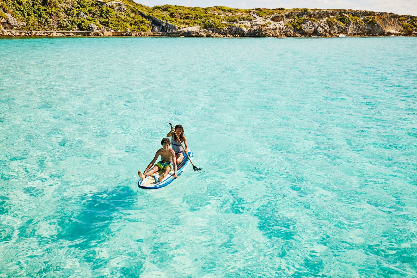 Teens paddleboarding in the Caribbean