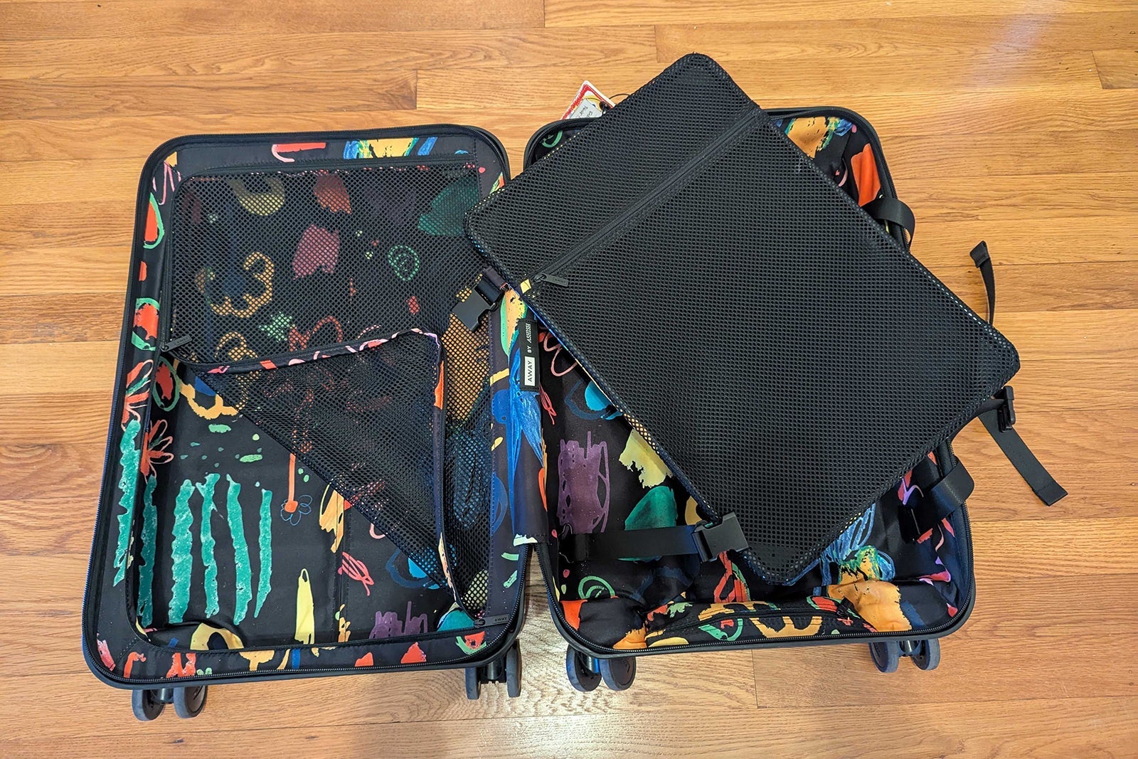 Multicolor hardside suitcase open on the floor