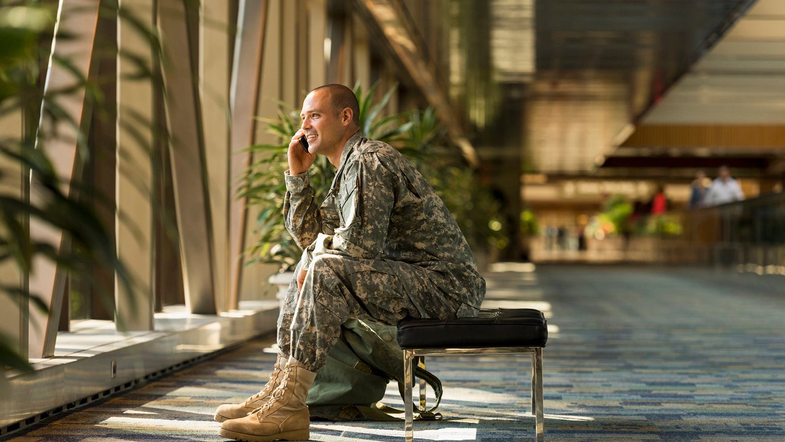 Caucasian soldier talking on cell phone in airport