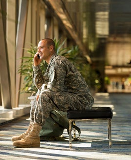 Caucasian soldier talking on cell phone in airport