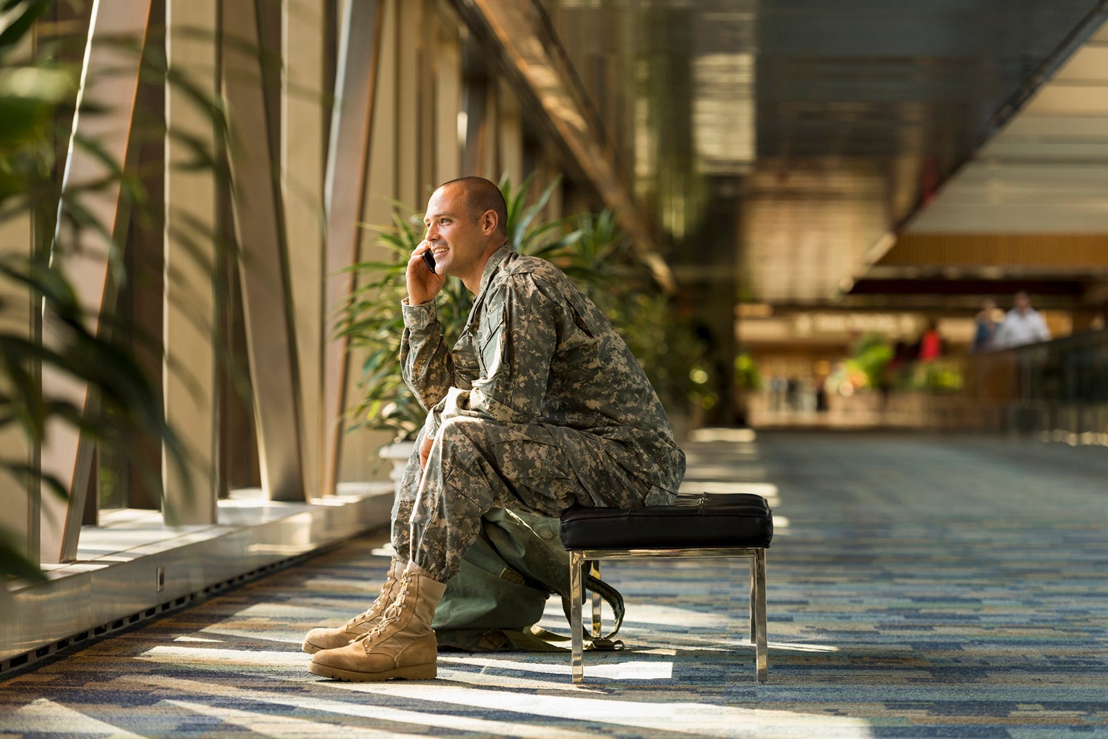 Caucasian soldier talking on cell phone in airport