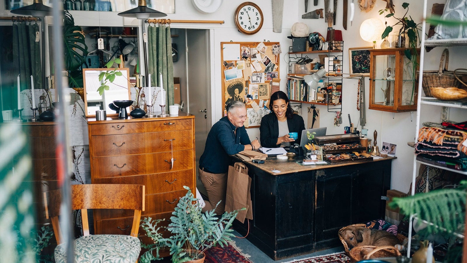 Smiling male and female owners discussing at antique shop