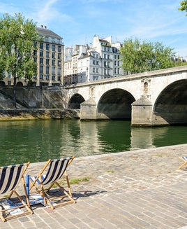 Deck chairs in the sun on the bank of the river Seine