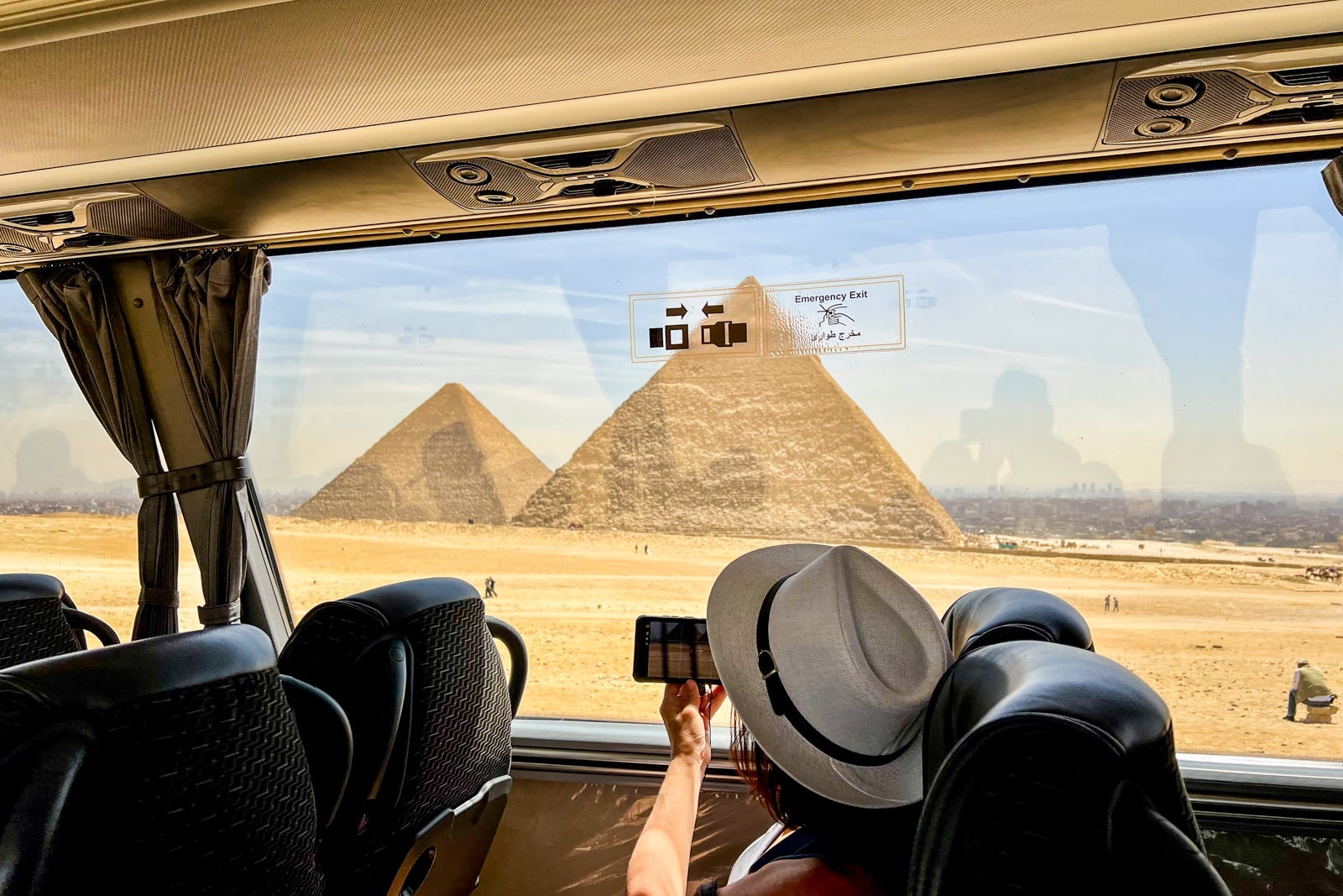 An AmaWaterways passenger snaps a photo of the Pyramids of Giza during a bus ride into the site
