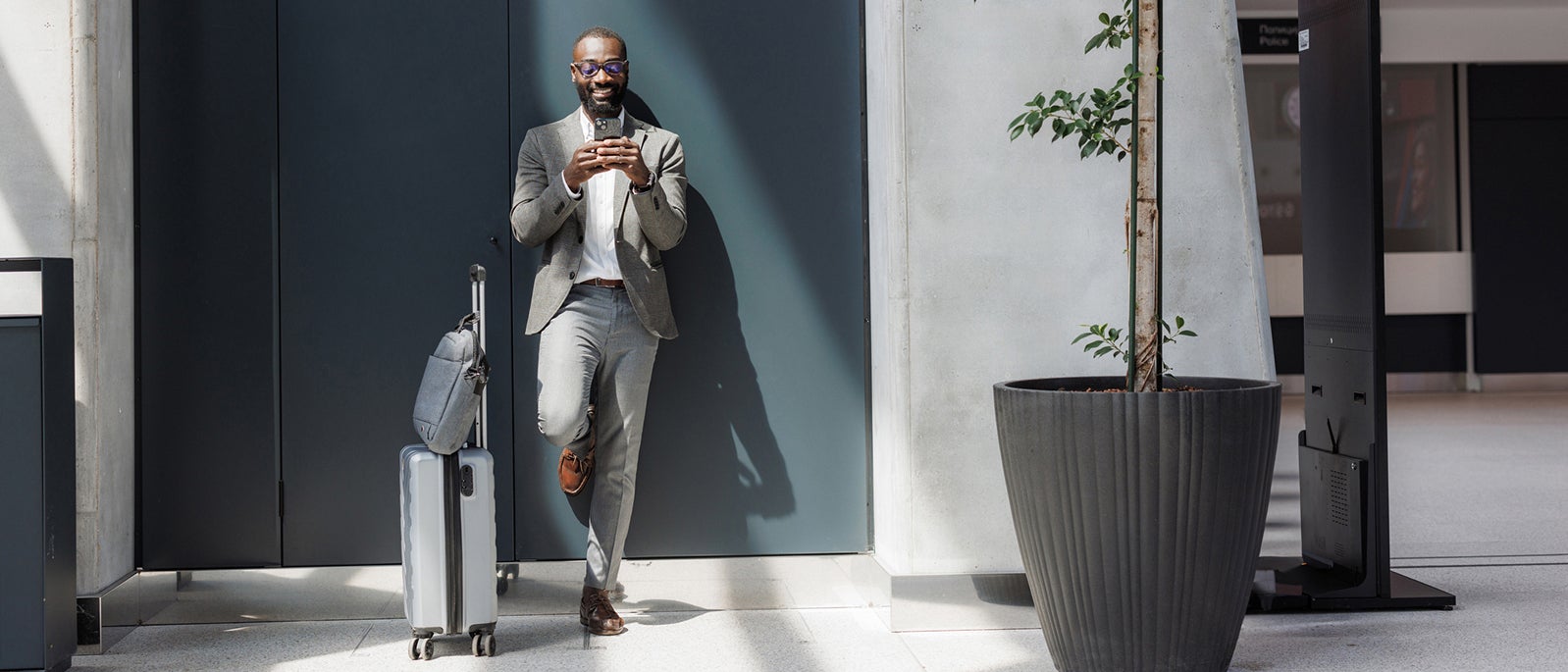 Business traveler using a smart phone at an airport