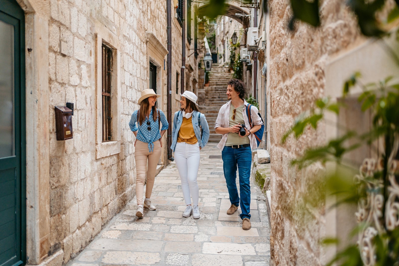 Three young tourists walking in an alley in Dubrovnik in Croatia.