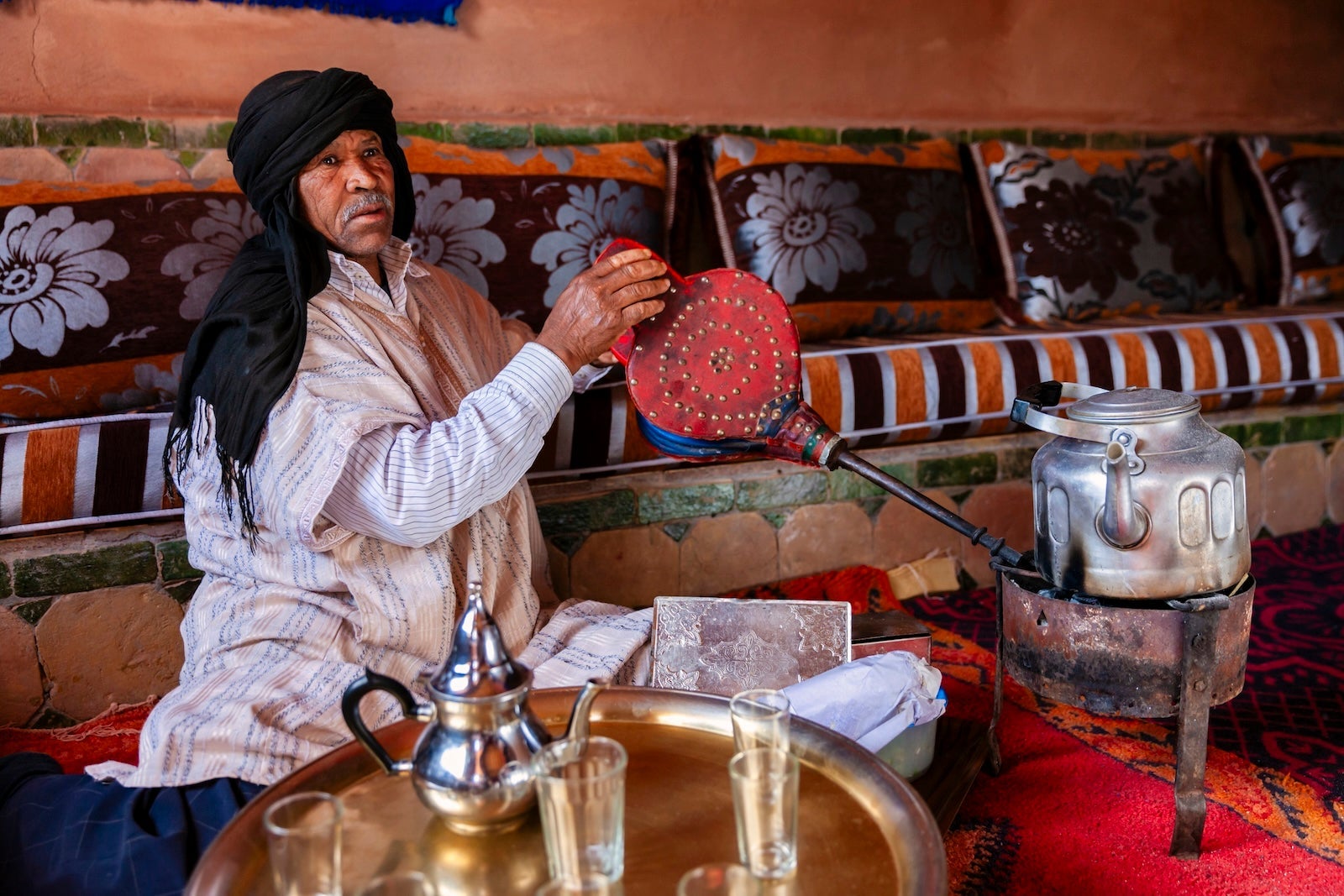 Moroccan man preparing Maghrebi mint tea.