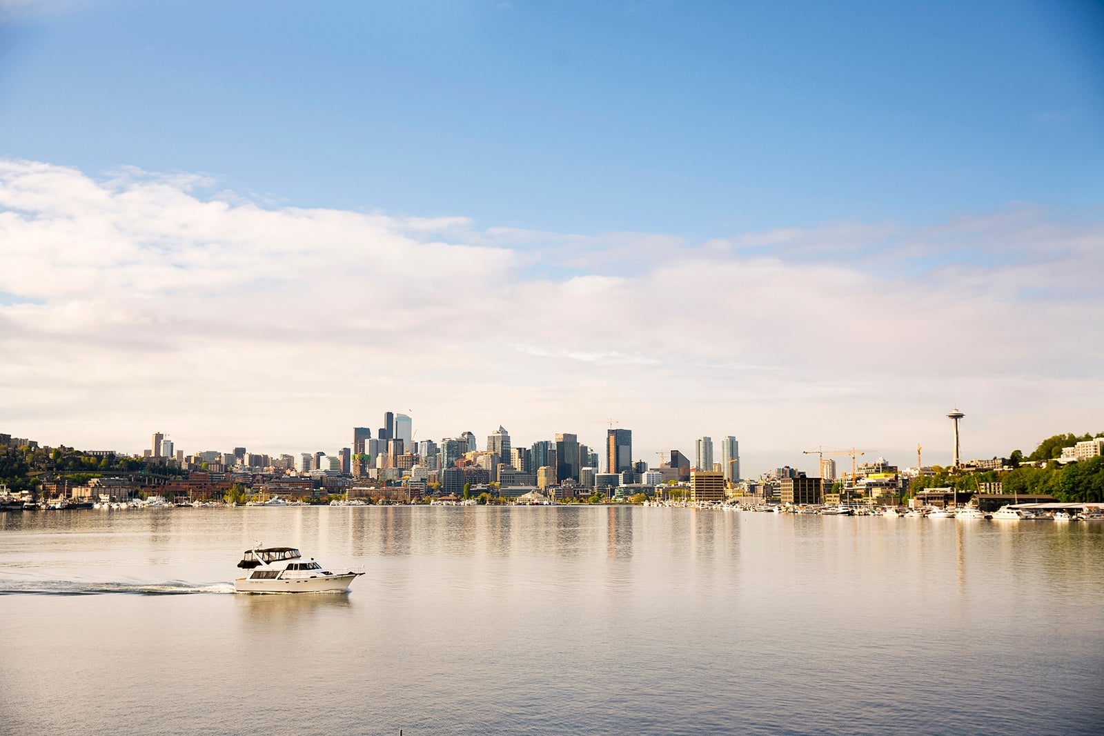 A boat passing by Lake Union with Seattle in the distance.