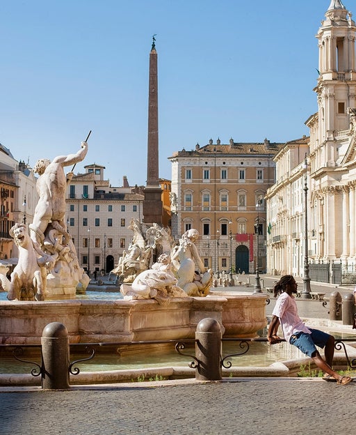 Man and woman at Bernini fountain in beautifully deserted Piazza Navona, Rome, Italy