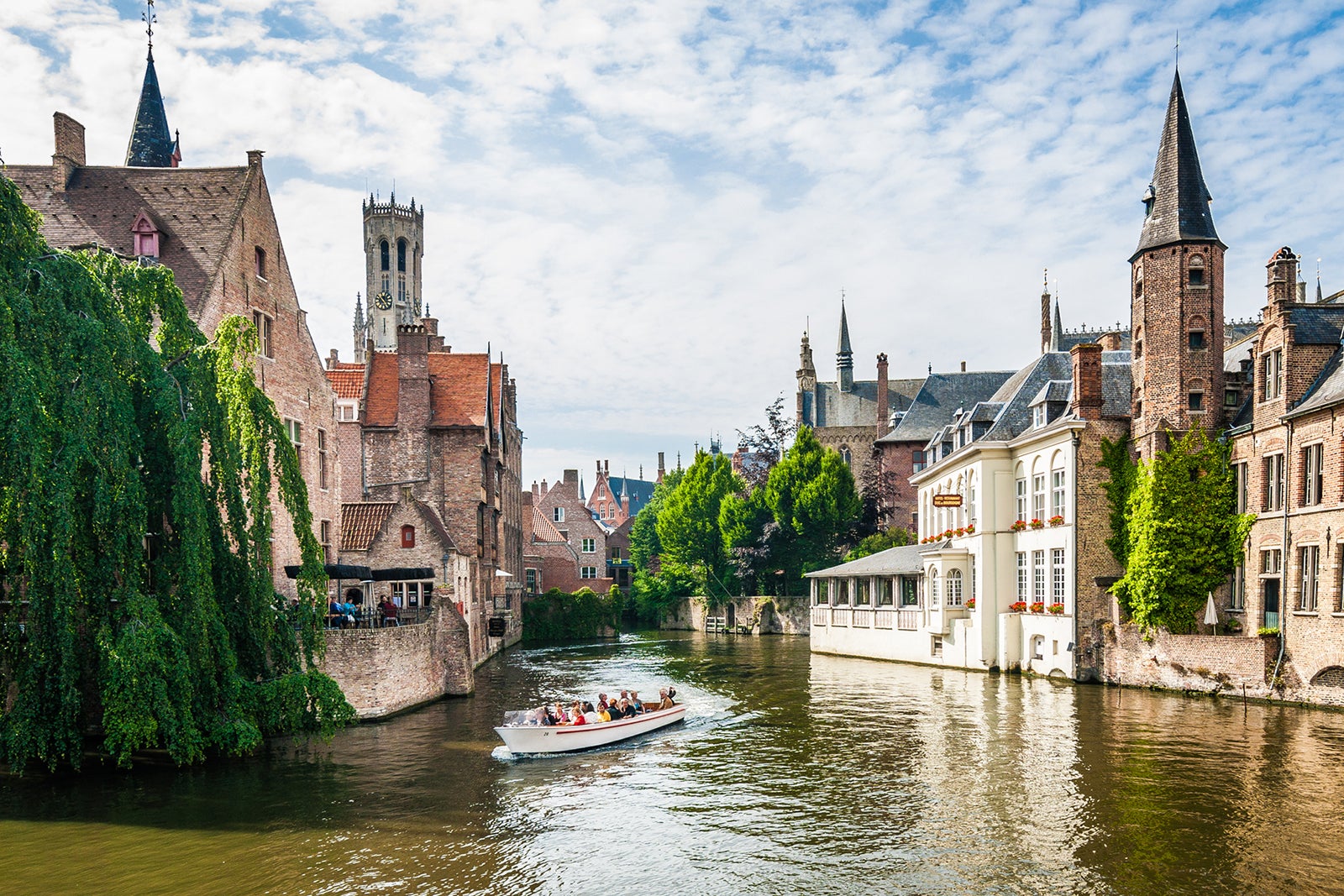 Tourist boat navigating through Bruges anals in Belgium