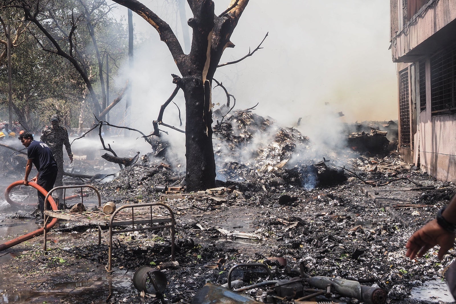 Firefighters work at the site where Air India flight 171 crashed
