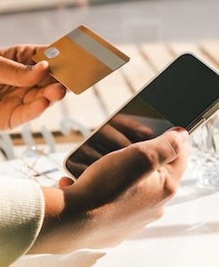 Woman using a credit card to pay online bills using mobile application