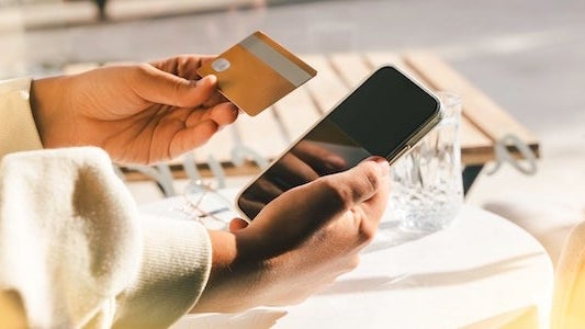 Woman using a credit card to pay online bills using mobile application