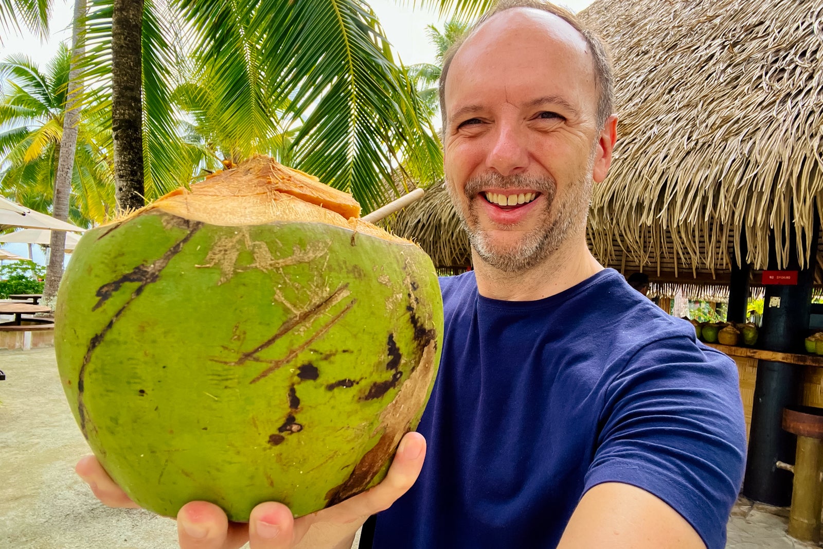 TPG's Gene Sloan with a coconut drink at Motu Mahana