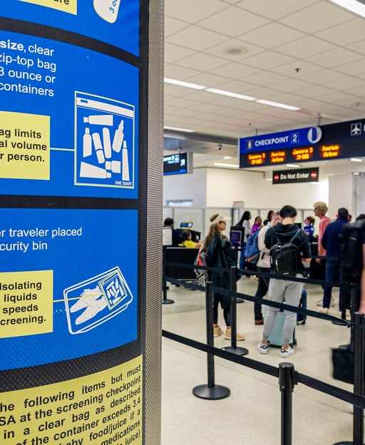 Signs explain the TSA's liquids policy at Miami International Airport (MIA).