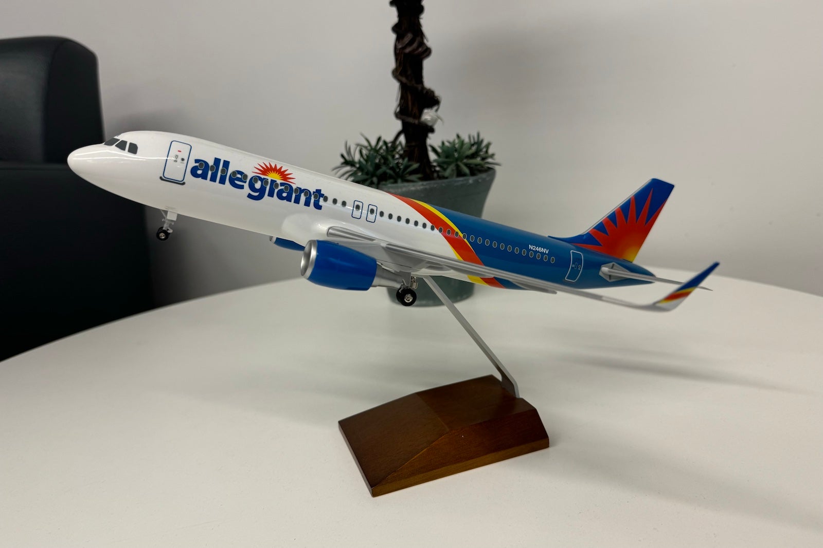 a model plane with white, blue, red and yellow paint and the Allegiant Air logo sits on a white table