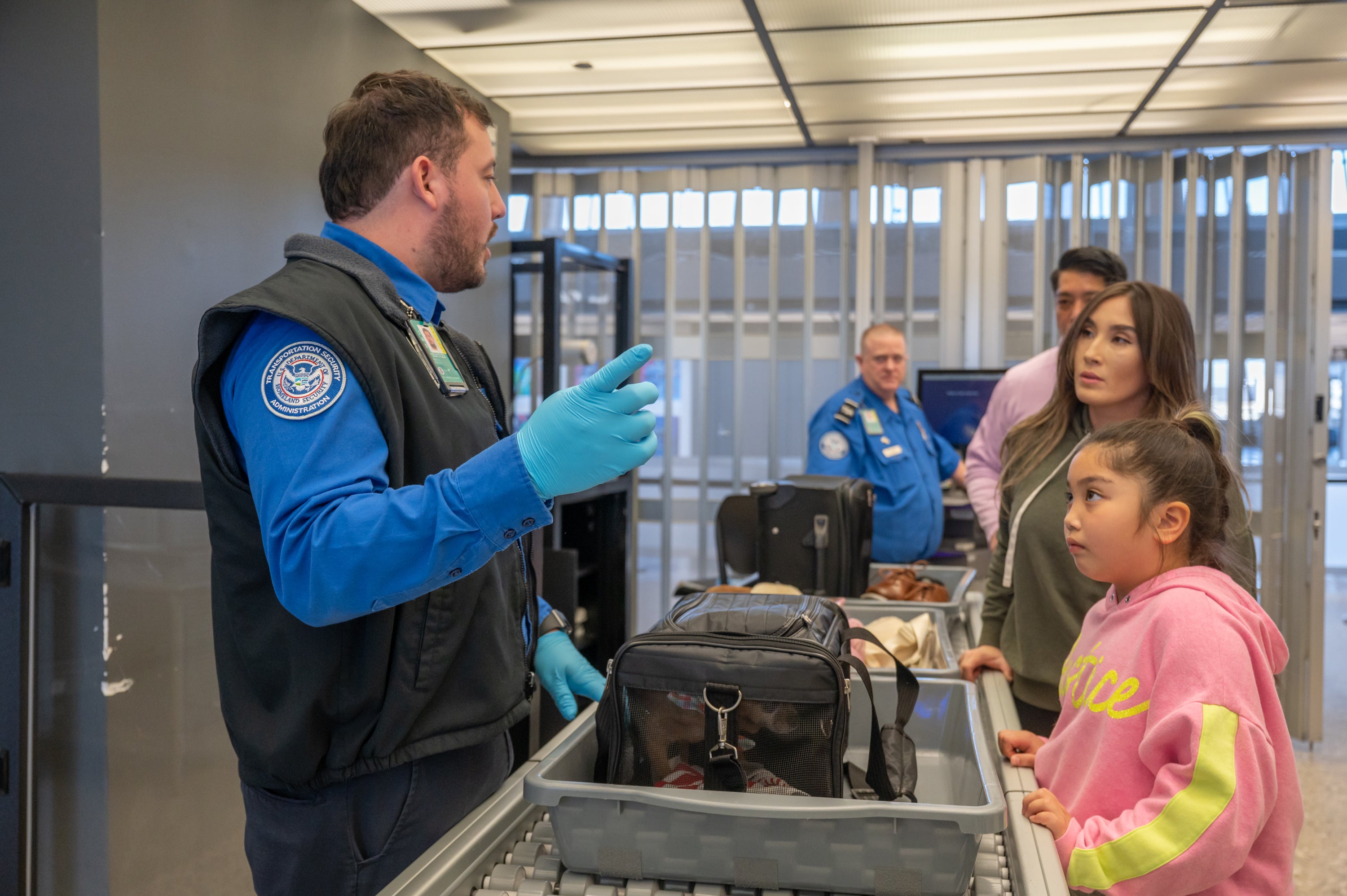 TSA agent talking to travelers