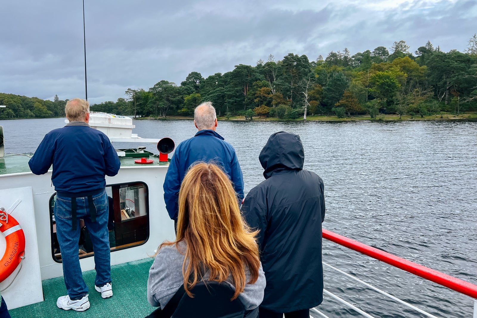 Globus tourgoers sightsee from the top deck of a tour boat on Loch Lomond.