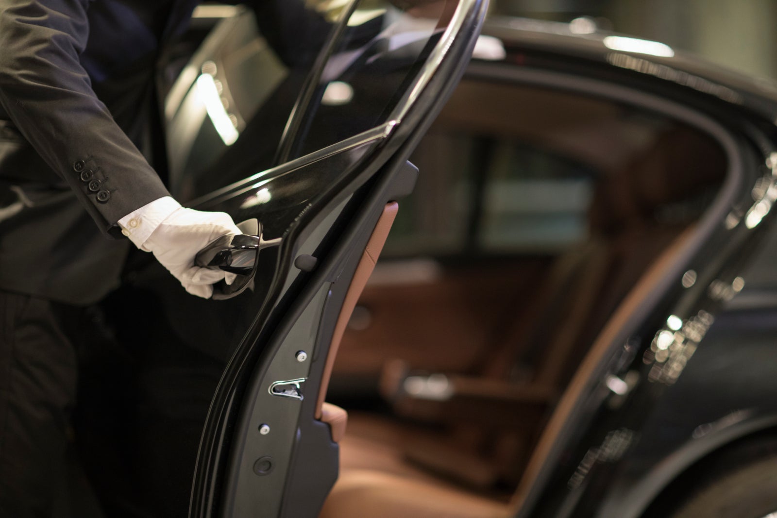 Chauffeur opening car door for passenger