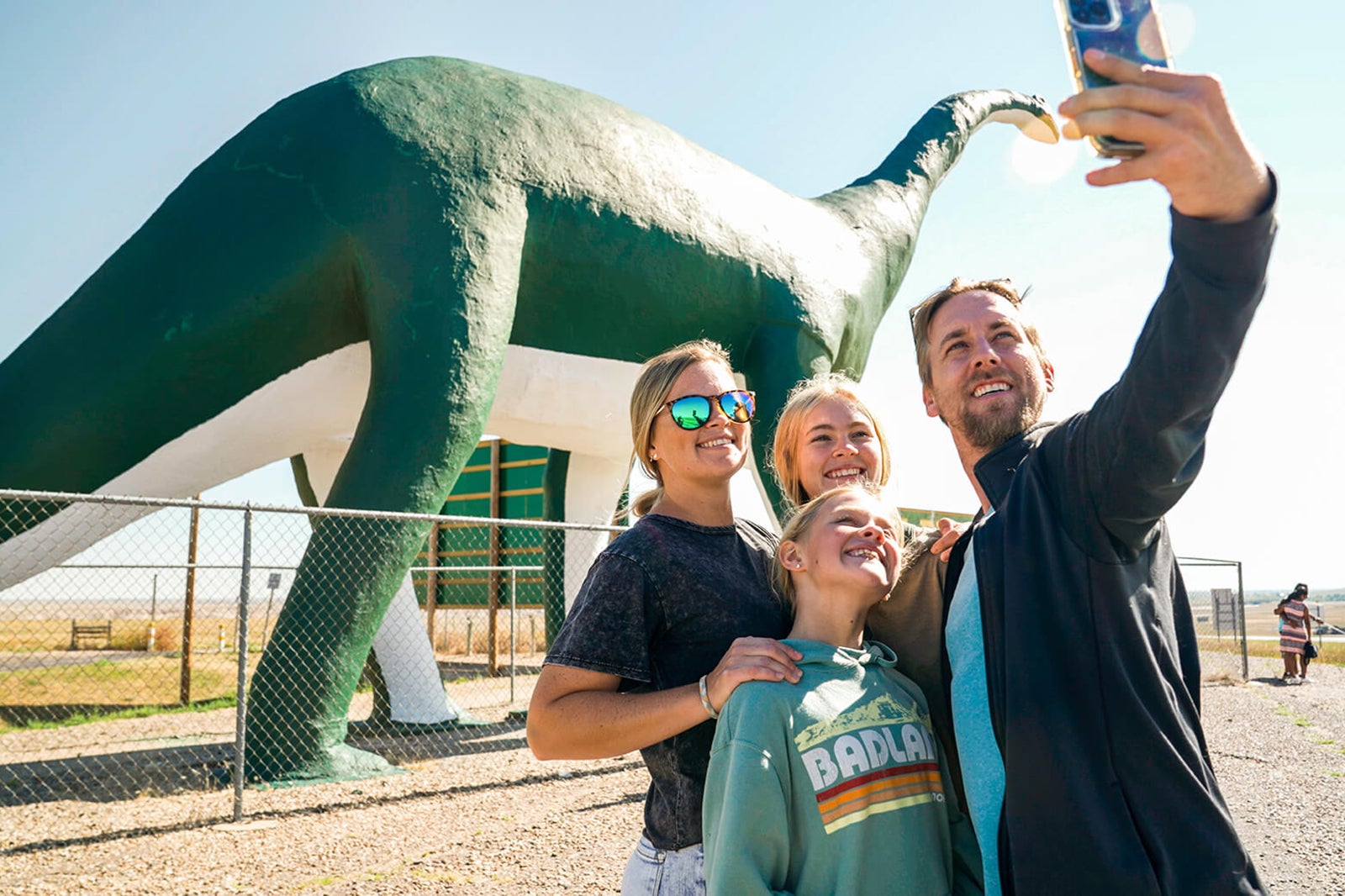 family takes photo at giant dinosaur at Wall Drug