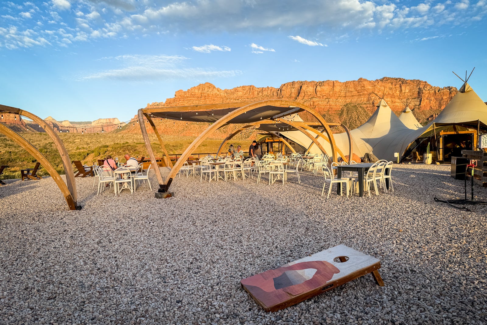 glamping resort tents and cornhole board